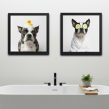 Two framed pictures of dogs in a bathroom setting with a bathtub and plant.